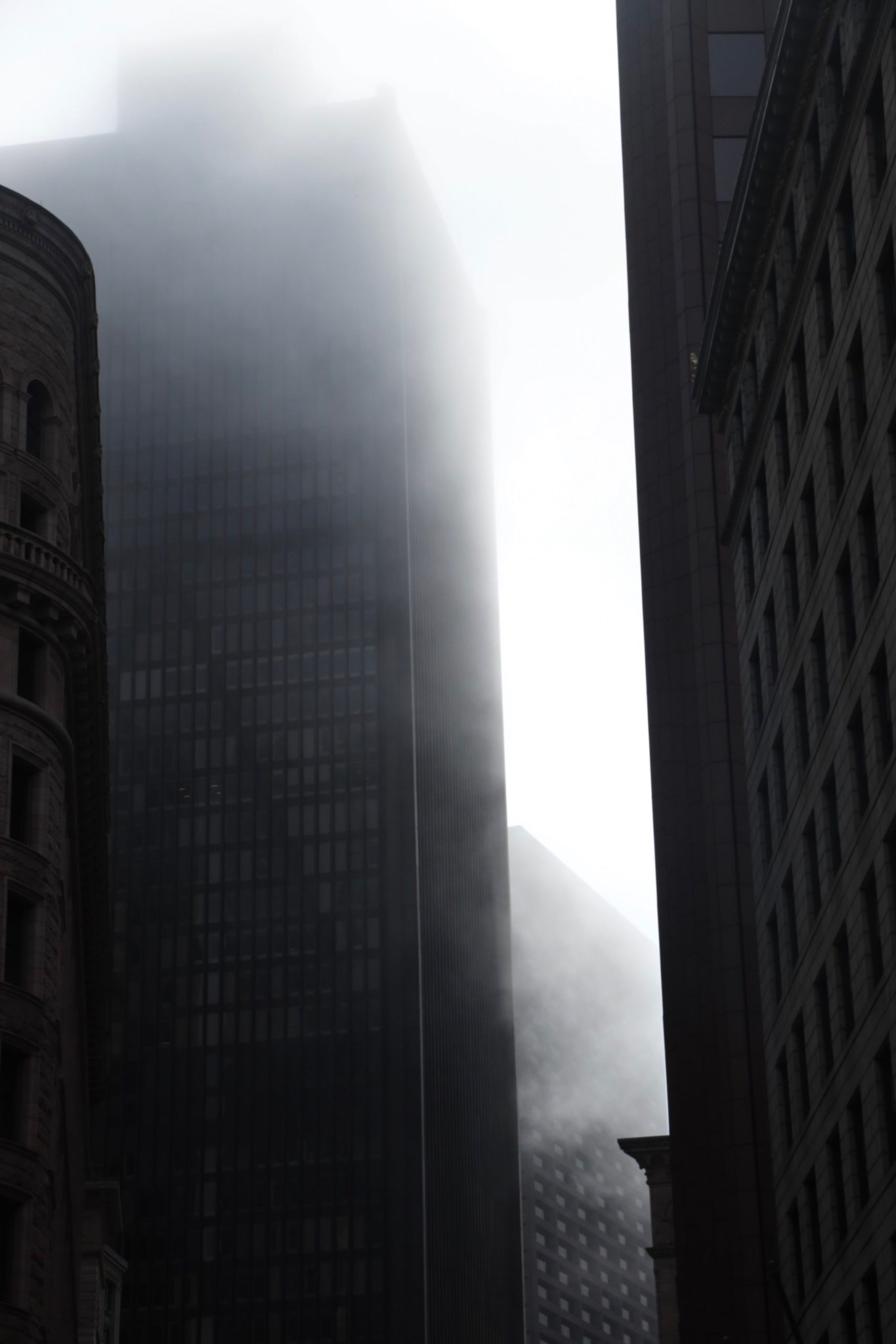 Gratte-ciel disparaissant dans la brume entre deux façades