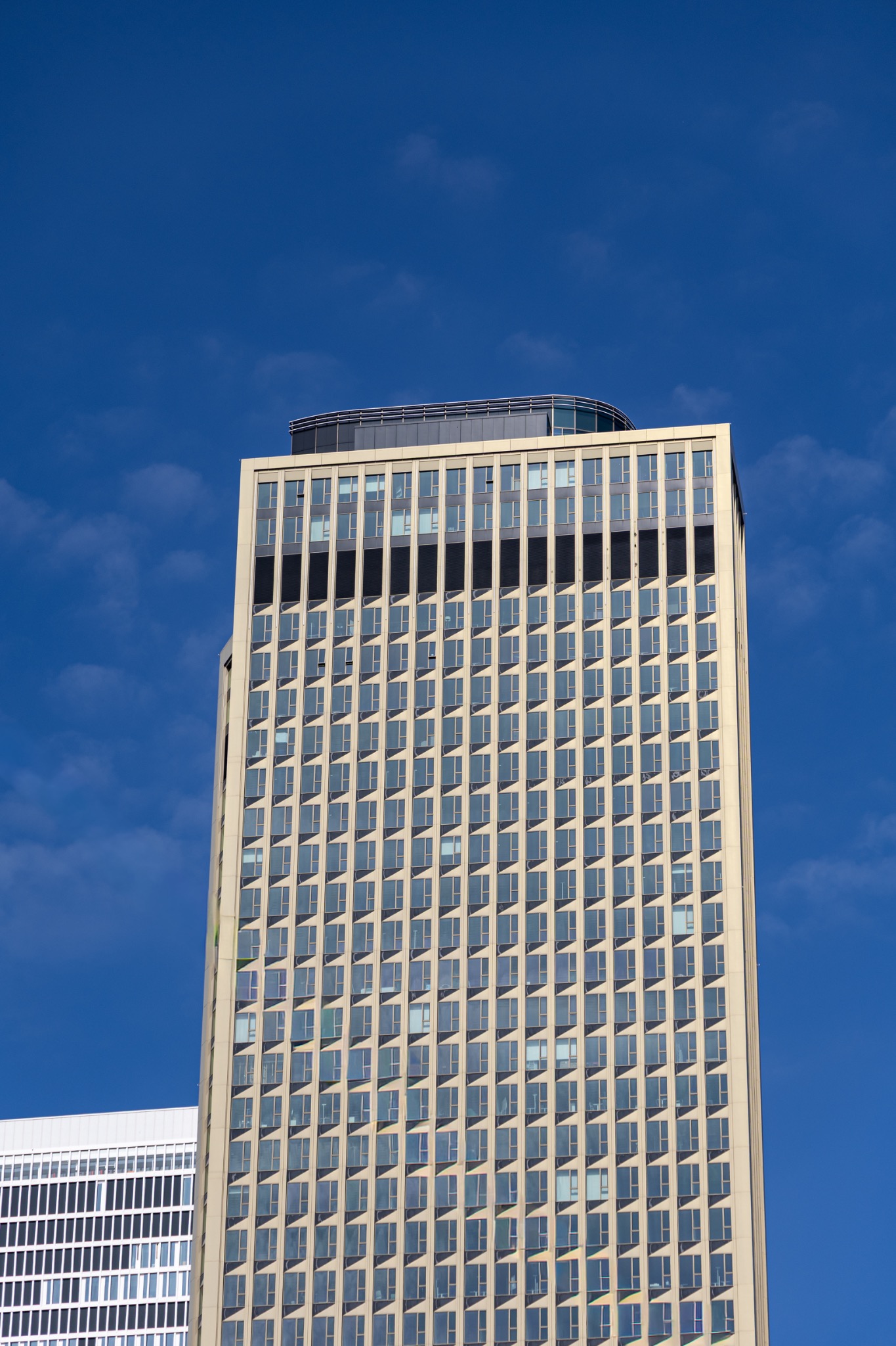 Tour moderniste dorée sur fond de ciel bleu
