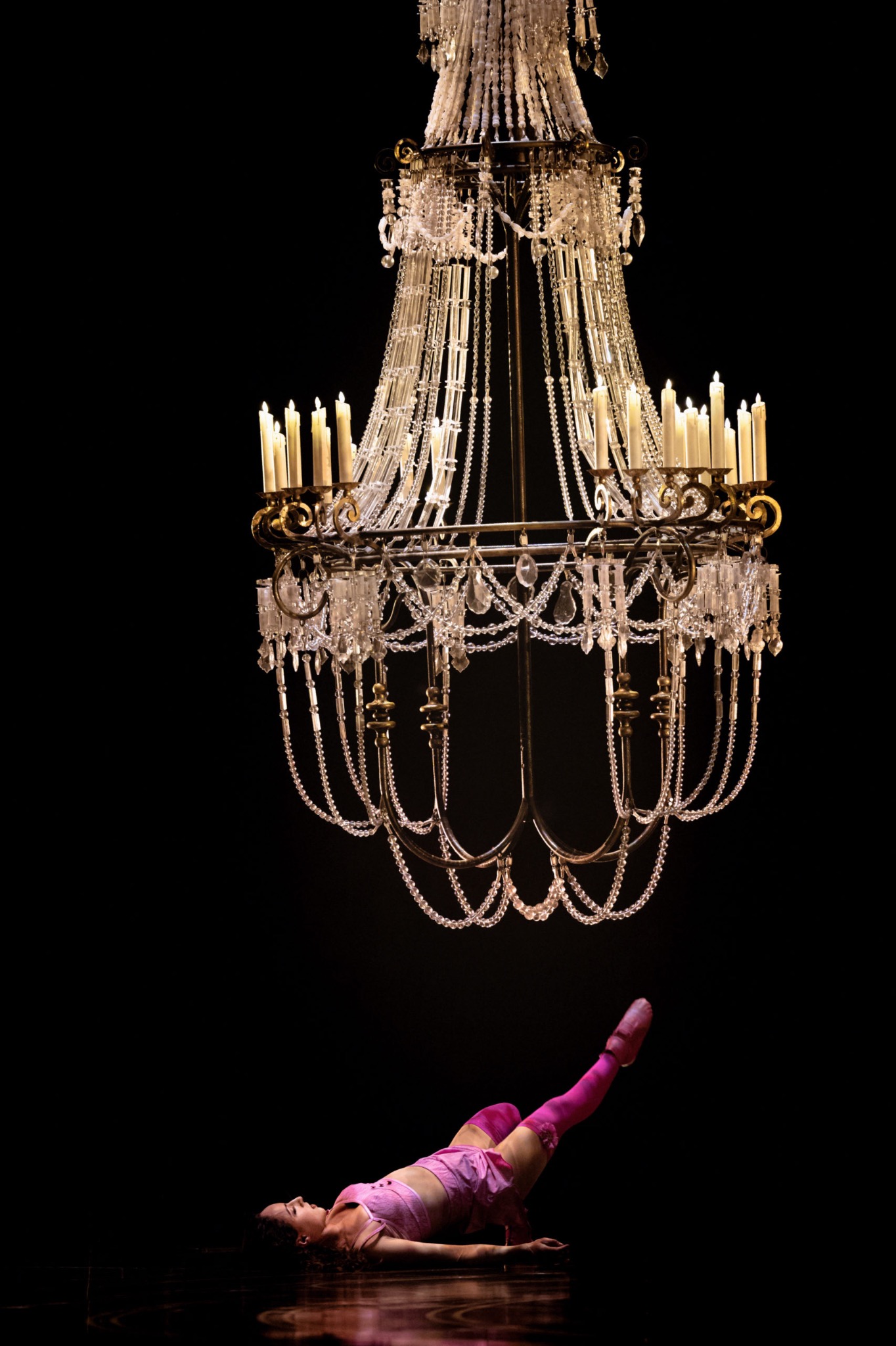Acrobate en rose sous un lustre monumental
