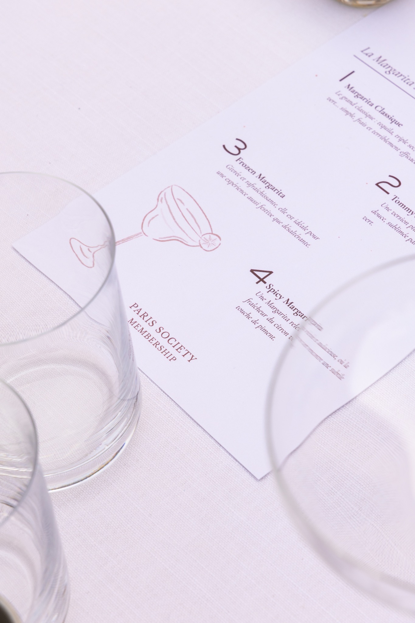 Fiche de recettes de cocktails dressée sur une table
